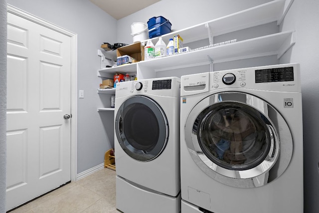 washroom with laundry area, baseboards, light tile patterned flooring, and separate washer and dryer