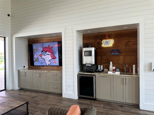 bar with beverage cooler, wooden walls, dark wood-type flooring, a sink, and wet bar