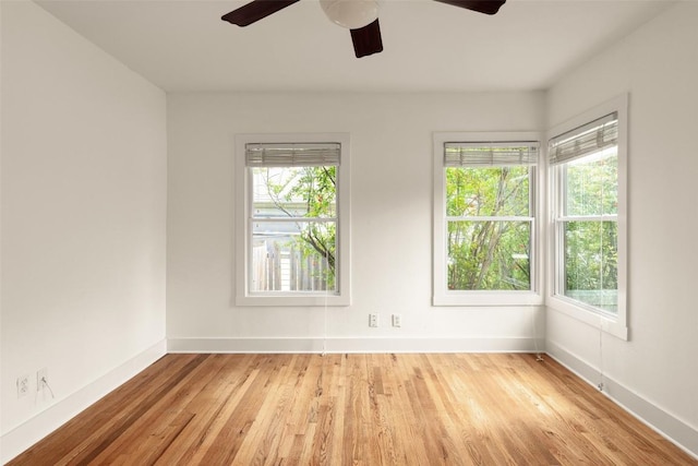 spare room featuring baseboards, ceiling fan, and wood finished floors