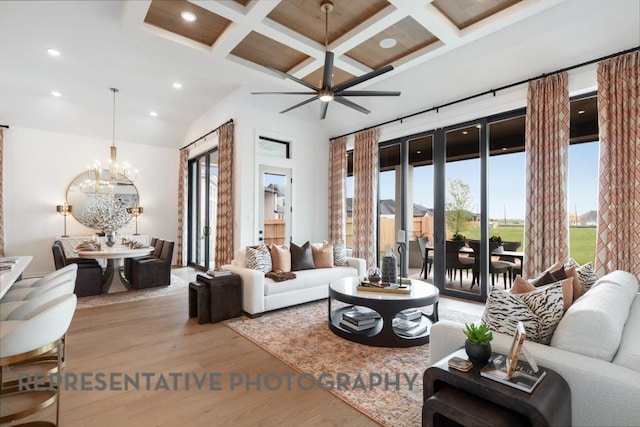 living area featuring wood finished floors, beamed ceiling, recessed lighting, coffered ceiling, and ceiling fan with notable chandelier