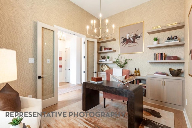 office area featuring light wood-style floors, baseboards, a notable chandelier, and wallpapered walls