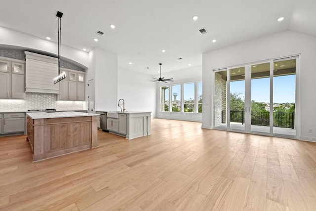 250 Leaning Rock Rdg, Austin, TX 78737 - kitchen featuring a kitchen island with sink, gray cabinetry, stainless steel dishwasher, open floor plan, and recessed lighting