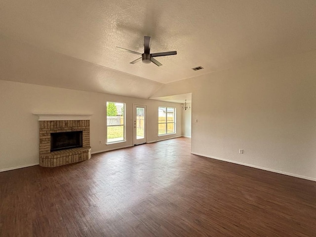 unfurnished living room featuring visible vents, a brick fireplace, baseboards, dark wood-style floors, and a ceiling fan