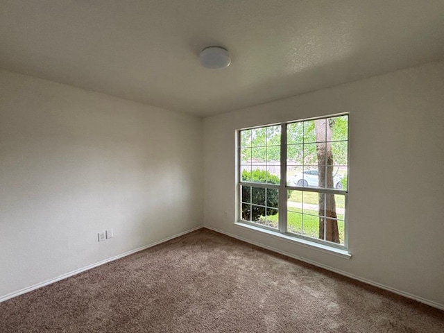 carpeted spare room with baseboards
