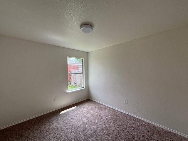 spare room featuring baseboards and carpet