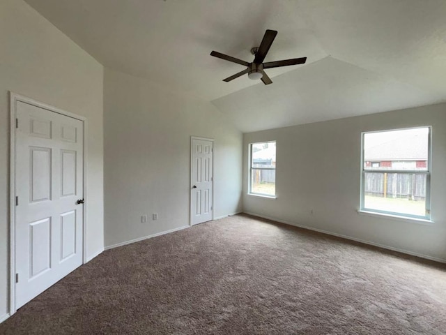 unfurnished bedroom featuring carpet flooring, baseboards, ceiling fan, and lofted ceiling