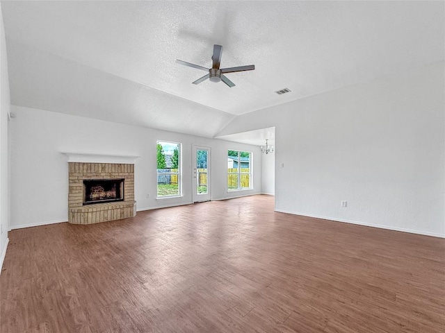 1614 Prickly Pear St, Lockhart, TX 78644 - unfurnished living room with ceiling fan, wood finished floors, a chandelier, a fireplace, and vaulted ceiling