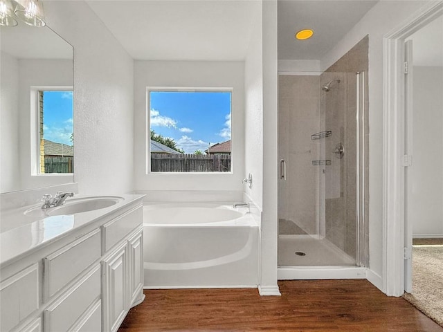 1614 Prickly Pear St, Lockhart, TX 78644 - bathroom featuring a bath, a shower stall, vanity, wood finished floors, and healthy amount of natural light