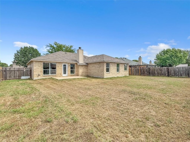 1614 Prickly Pear St, Lockhart, TX 78644 - back of property with a patio, a fenced backyard, brick siding, and a chimney