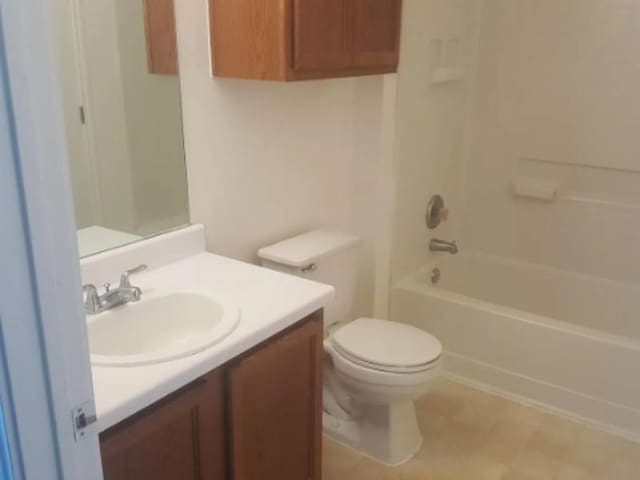bathroom with vanity, shower / bathtub combination, and toilet