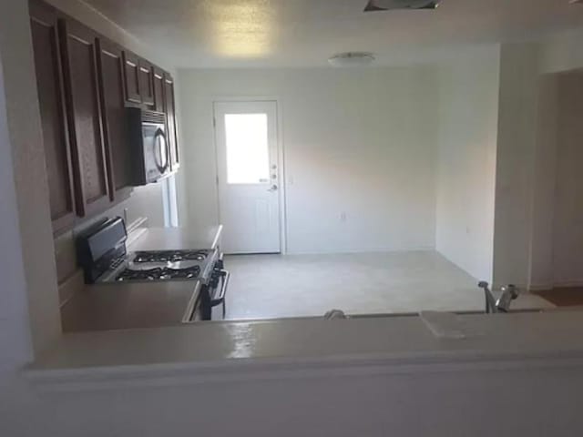 kitchen with dark brown cabinets and range with gas stovetop