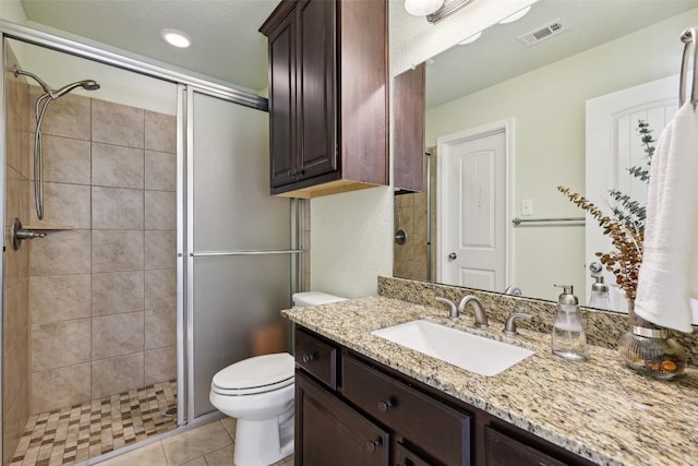 bathroom with visible vents, vanity, tile patterned flooring, toilet, and a shower stall