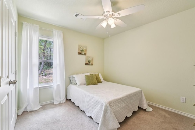 carpeted bedroom featuring baseboards, ceiling fan, and visible vents
