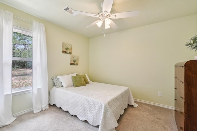 carpeted bedroom featuring baseboards, a ceiling fan, and visible vents