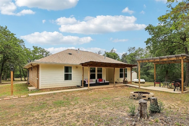 rear view of property with an outdoor living space with a fire pit, a pergola, a patio, a shingled roof, and a yard