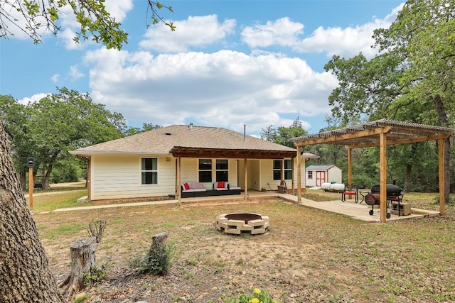 rear view of house featuring a pergola, a storage shed, an outdoor living space with a fire pit, an outbuilding, and a patio area