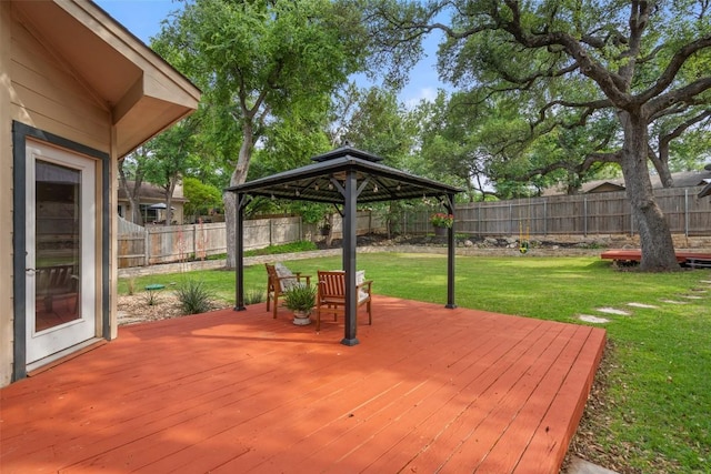 wooden terrace featuring a lawn, a gazebo, and a fenced backyard