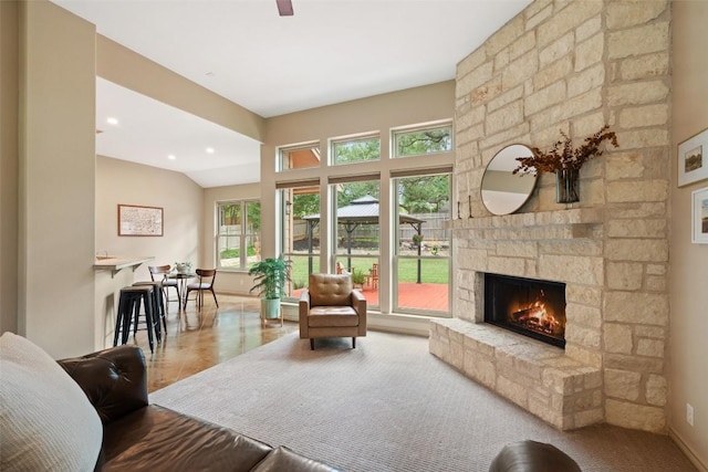 living room with baseboards, a stone fireplace, and wood finished floors