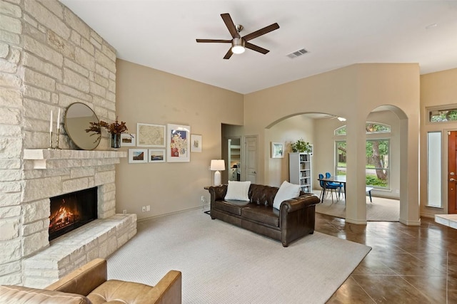 15205 N Flamingo Dr, Austin, TX 78734 - living area with arched walkways, ceiling fan, a high ceiling, a stone fireplace, and baseboards