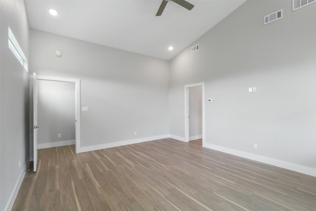 unfurnished room with visible vents, ceiling fan, wood finished floors, and high vaulted ceiling