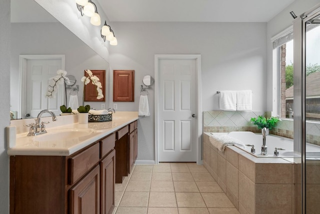 full bathroom featuring a sink, tile patterned floors, a garden tub, and double vanity