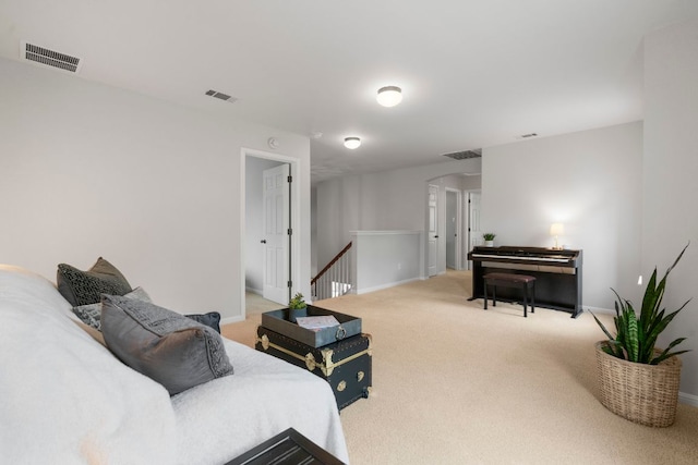 carpeted living area featuring baseboards, arched walkways, and visible vents