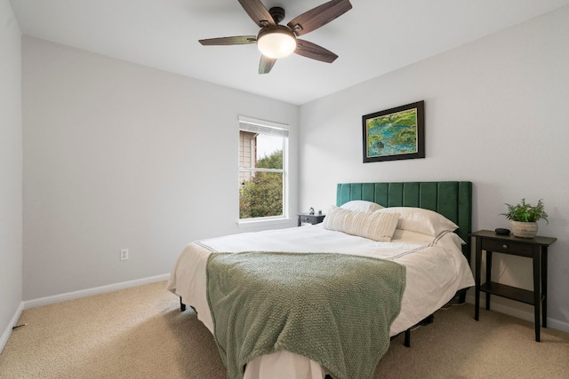 bedroom with light colored carpet, baseboards, and ceiling fan