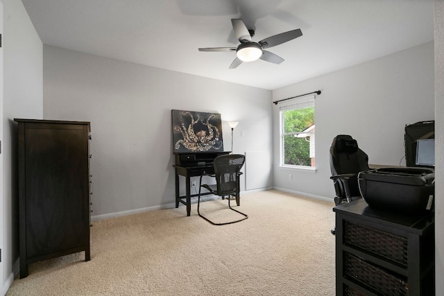 office featuring baseboards, light carpet, and ceiling fan