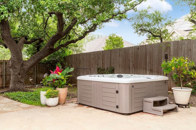 view of patio with a fenced backyard and a hot tub