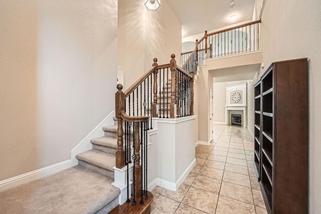 404 Scarlet Maple Dr, Cedar Park, TX 78613 - stairs featuring a towering ceiling, tile patterned flooring, baseboards, and a tile fireplace