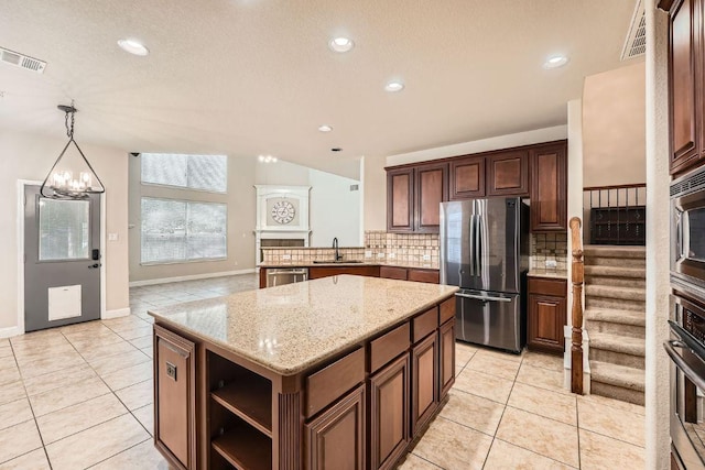 404 Scarlet Maple Dr, Cedar Park, TX 78613 - kitchen featuring stainless steel appliances, a sink, tasteful backsplash, light tile patterned floors, and a kitchen island