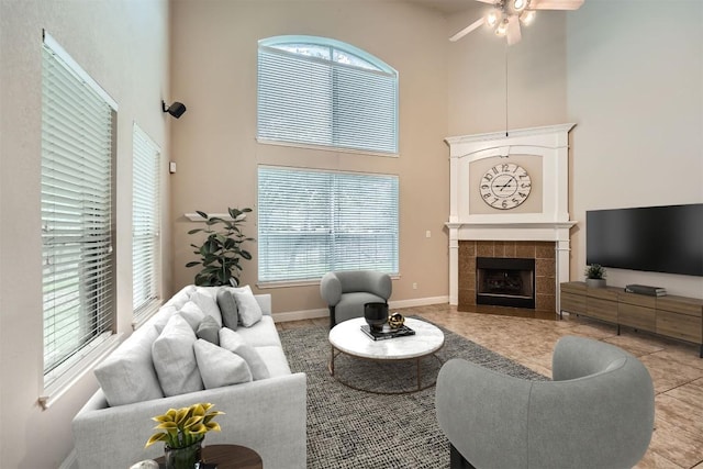 404 Scarlet Maple Dr, Cedar Park, TX 78613 - tiled living area featuring a tiled fireplace, baseboards, a towering ceiling, and ceiling fan