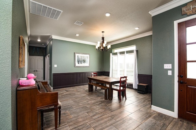 1066 Vista Dr, Salado, TX 76571 - dining area featuring ornamental molding, a chandelier, a wainscoted wall, healthy amount of natural light, and a textured wall