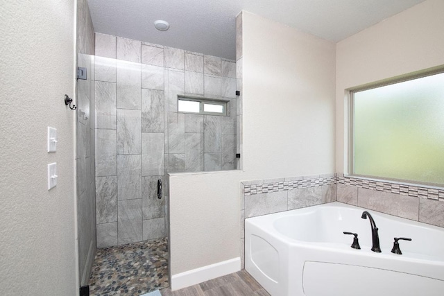 1066 Vista Dr, Salado, TX 76571 - bathroom featuring a stall shower, a bath, wood finished floors, and baseboards