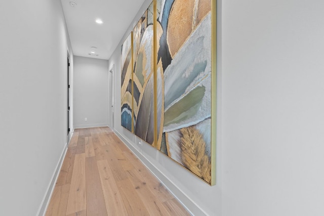 hallway with light wood-type flooring, recessed lighting, and baseboards
