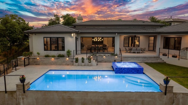 back of property featuring outdoor dining area, a chimney, stucco siding, and a tile roof