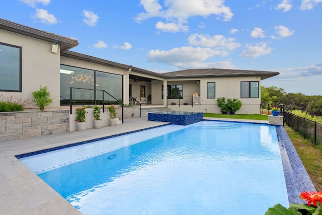 view of pool featuring a patio, a ceiling fan, fence, and a pool with connected hot tub