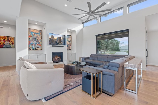 18304 Cedar Sage Ct, Lago Vista, TX 78645 - living area with a warm lit fireplace, ceiling fan, baseboards, and light wood finished floors