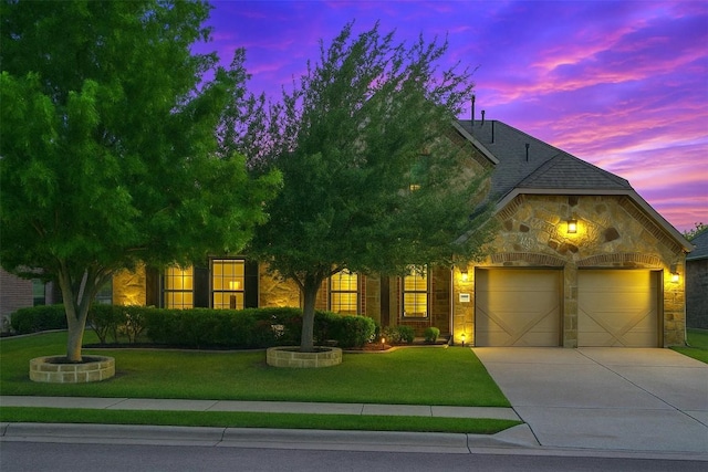 view of front of property featuring a garage, concrete driveway, a front lawn, and stone siding