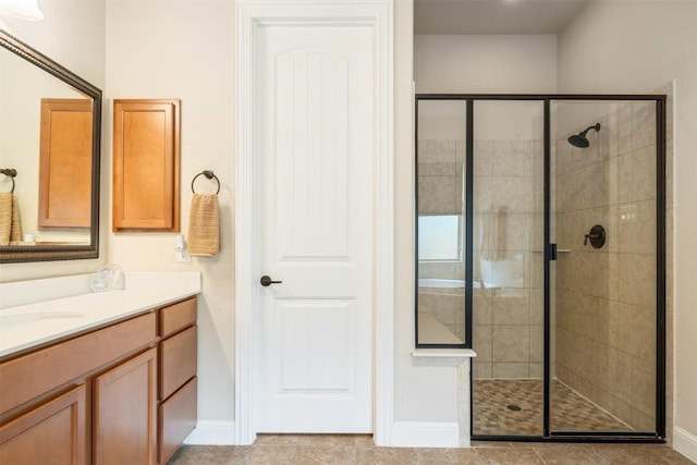 full bathroom featuring baseboards, a shower stall, and vanity