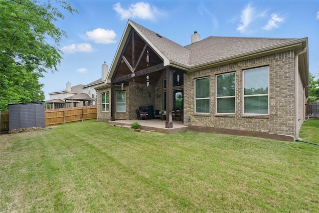 rear view of house featuring brick siding, a fenced backyard, and a patio area