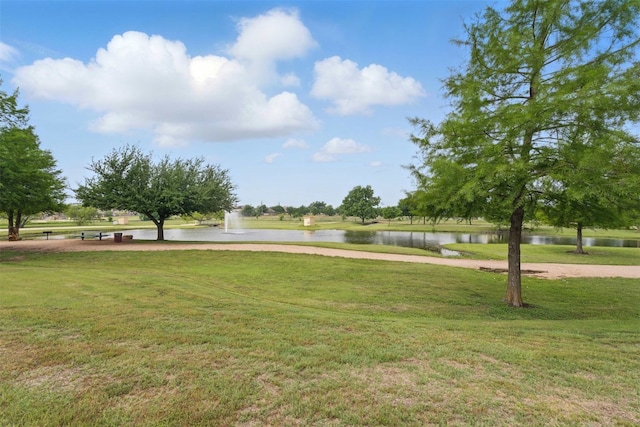 view of property's community featuring a lawn and a water view