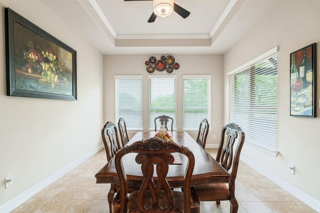 dining space featuring crown molding, a ceiling fan, a raised ceiling, and light tile patterned floors