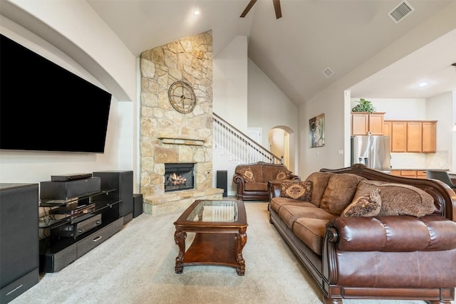 living area with carpet floors, arched walkways, high vaulted ceiling, a ceiling fan, and visible vents