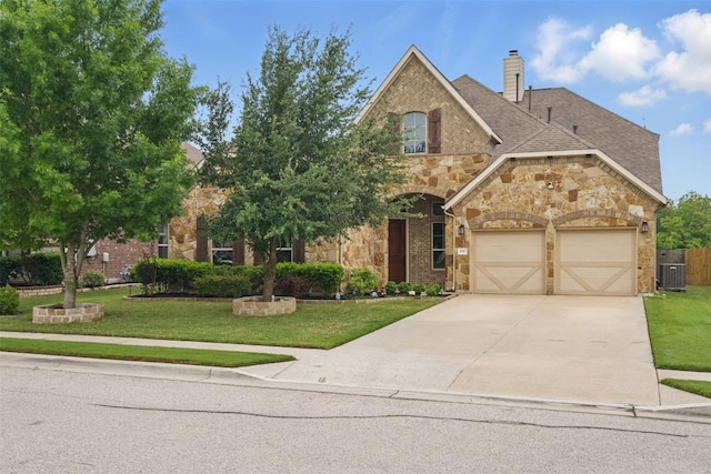 view of front of property featuring concrete driveway, a front yard, stone siding, and a garage