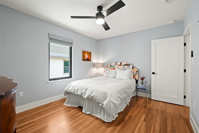 bedroom with baseboards, a ceiling fan, and wood finished floors