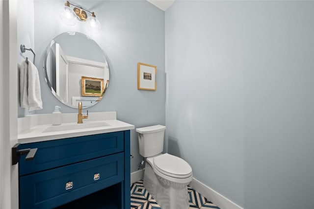 bathroom with vanity, baseboards, and toilet