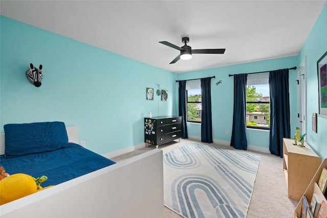 carpeted bedroom featuring baseboards and a ceiling fan