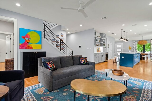 living area featuring beverage cooler, a ceiling fan, recessed lighting, light wood-type flooring, and visible vents