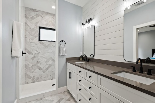 bathroom featuring visible vents, a sink, a walk in shower, and double vanity